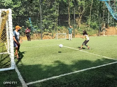 a group of people playing soccer on a field at Vythiri Resort in Vythiri