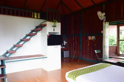 a bedroom with a bed and a staircase in a room at Avadale Wayanad - Stag Groups Not Allowed in Kalpetta