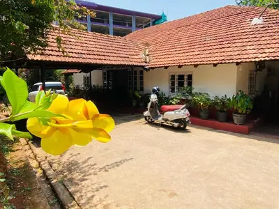 a scooter parked in front of a house at Coorg Daffodil Guesthouse in Madikeri