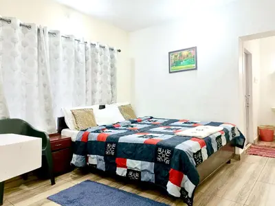 a bedroom with a bed with a red white and blue quilt at QUEENS COTTAGE - individual cottage in Ooty