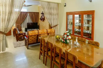 a dining room with a table and a couch at Belljem Homes -your own private resort -3 BHK GF in Trichūr