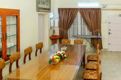 a dining room with a wooden table and chairs at Belljem Homes -your own private resort -3 BHK GF in Trichūr