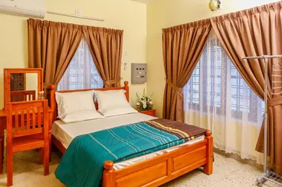 a bedroom with a bed and two large windows at Belljem Homes -your own private resort -3 BHK GF in Trichūr