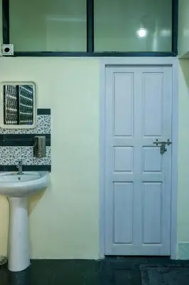 a bathroom with a white door and a sink at Belljem Homes -your own private resort -3 BHK GF in Trichūr