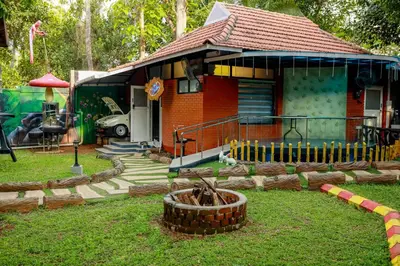 a small red house with a playground in front of it at Belljem Homes -your own private resort -3 BHK GF in Trichūr