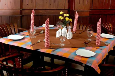 a table with plates and wine glasses on top at Devasura inn in Guruvāyūr