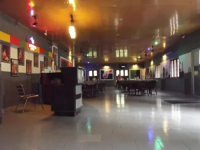 an empty room with tables and chairs in a building at Devasura inn in Guruvāyūr
