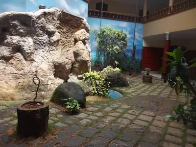 a garden in a building with rocks and plants at Devasura inn in Guruvāyūr