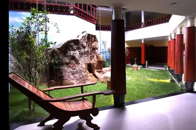 a bench in a room with a large window at Devasura inn in Guruvāyūr