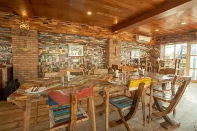 a dining room with a large wooden table and chairs at State Beach Resort And Spa in Kannur