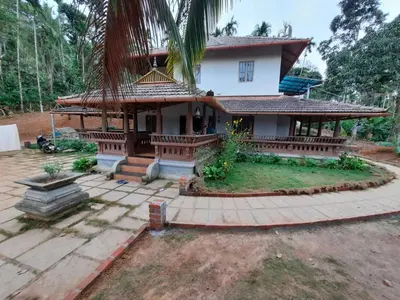 a house with a large yard in front of it at Wayal Wayanad Heritage villa in Panamaram