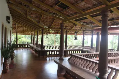 an empty porch with benches in a building at Wayal Wayanad Heritage villa in Panamaram