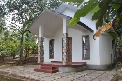 a small white house with a porch at Wayal Wayanad Honey moon villa in Panamaram
