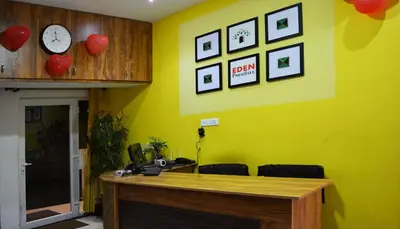 an office with a yellow wall with a desk and a clock at EDEN Paradisee in Ooty