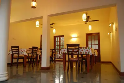 a dining room with a table and chairs and a ceiling at The Villa Romantica in Nedumbassery