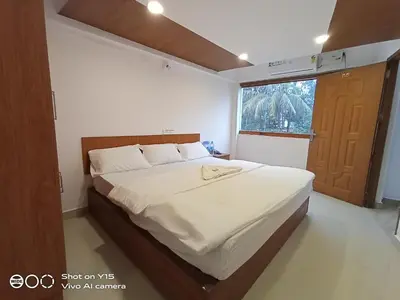 a bedroom with a bed and a large window at Hotel Magnet in Marayoor