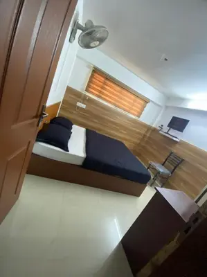 a bedroom with a bed and a window at Hotel Magnet in Marayoor
