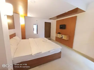 a bedroom with a large bed in a room at Hotel Magnet in Marayoor