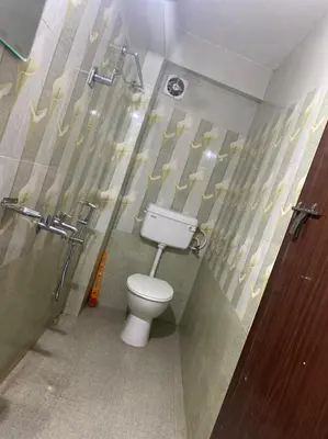 a bathroom with a toilet in a stall with a shower at Hotel Magnet in Marayoor