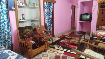 a living room with a chair and a tv at Dreams River view home stay coorg 2 in Kushālnagar