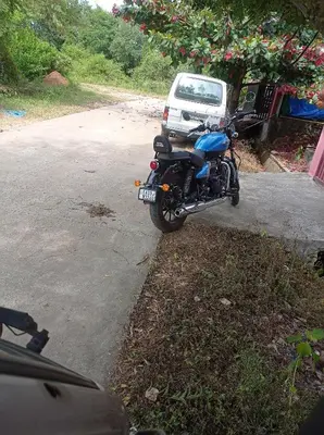 a blue motorcycle parked on the side of a road at Dreams River view home stay coorg 2 in Kushālnagar