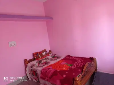 a bedroom with a bed in a pink room at Dreams River view home stay coorg 2 in Kushālnagar