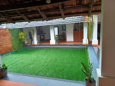 a patio with a green lawn in a house at Kayyalas Courtyard in Trichūr