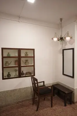 a room with a chair and a mirror and a table at Kayyalas Courtyard in Trichūr