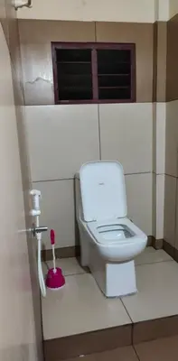 a bathroom with a white toilet in a stall at MALABAR Residency in Perintalmanna