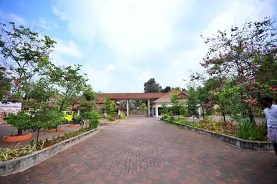 a brick road in front of a building with trees at Clay House in Trichūr