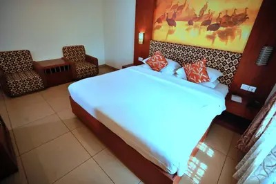 a bedroom with a large bed with red pillows at Clay House in Trichūr