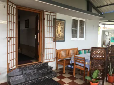 a dining room with a table and chairs in a room at Shantham Service Apartments, Kinathukadavu, Coimbatore in Coimbatore