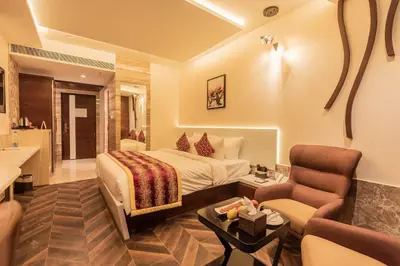 a hotel room with a bed and a living room at Hotel Park Elanza Coimbatore in Coimbatore