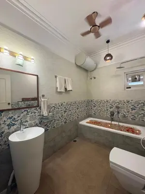 a bathroom with a tub and a toilet and a sink at Elegant holiday homes Coorg in Madikeri