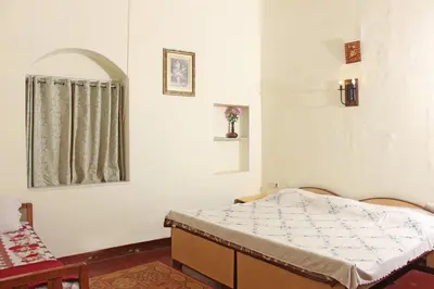 a small bedroom with a bed and a window at HS Holiday Home in Coonoor