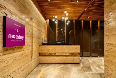 a lobby with a purple sign on a wall at Nexstay Treats Inn in Kozhikode