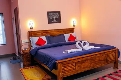 a bedroom with a bed with two towels on it at Aldora Holiday Homes in Vythiri