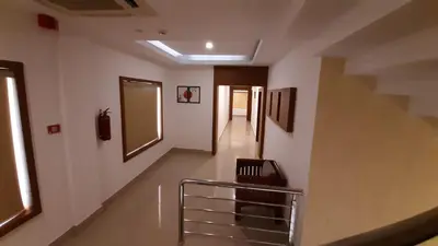 a hallway with stairs and a mirror on the wall at HOTEL SURYA in Iritti