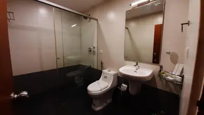 a bathroom with a toilet and a sink and a mirror at HOTEL SURYA in Iritti