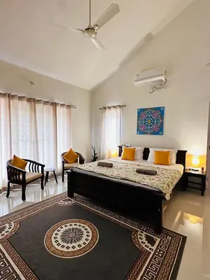 a bedroom with a large bed with a rug at Green Castle in Gonikoppal