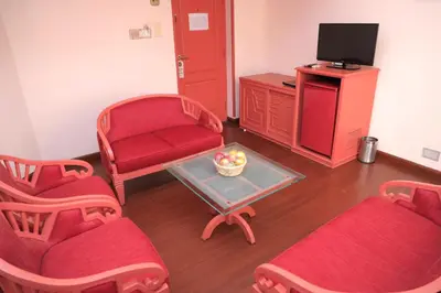 a living room with two chairs and a tv at Fort Gate Hotels & Resorts in Trichūr