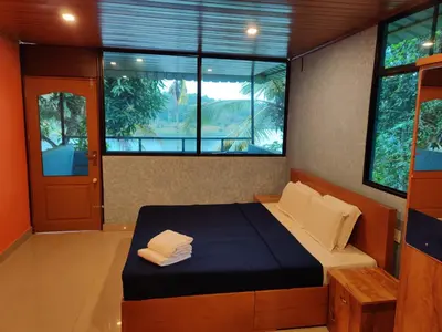 a bedroom with a bed in a room with windows at 7 Heaven Resorts in Ambalavayal