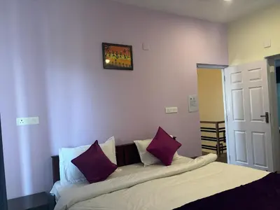a bedroom with a bed with purple and white pillows at Casa Felicia-Adding happy moments to your diary in Ooty