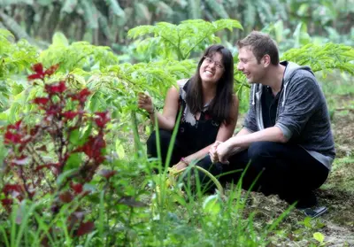 a man and a woman sitting in a garden at The Woods Resorts Wayanad in Sultan Bathery