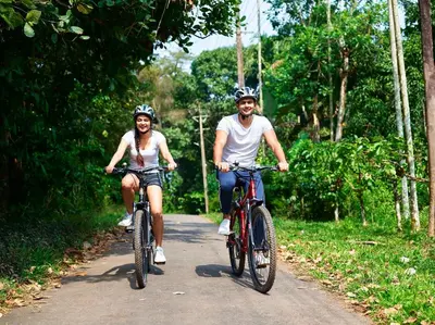 two people riding bikes down a dirt road at The Woods Resorts Wayanad in Sultan Bathery