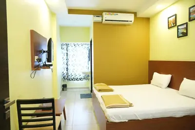 a room with a bed and a table and a window at Sri Krishnan Residency in Pollāchi