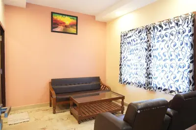a living room with a couch and a coffee table at Sri Krishnan Residency in Pollāchi