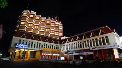 a large building with a pointed roof at night at Manuelsons Malabar Palace in Kozhikode