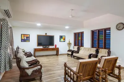a living room with couches and a flat screen tv at StayVista at Springhills Villa & Ayurvedic Spa in Cochin