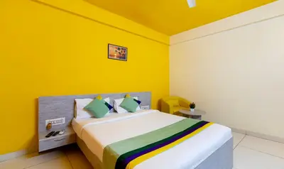 a bedroom with a bed with yellow walls at Treebo Four Seasons in Mysore
